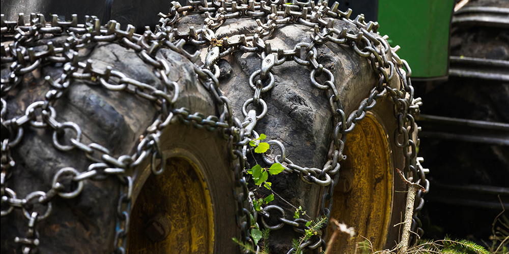 Wheel of a forest machine in the forest on moss,